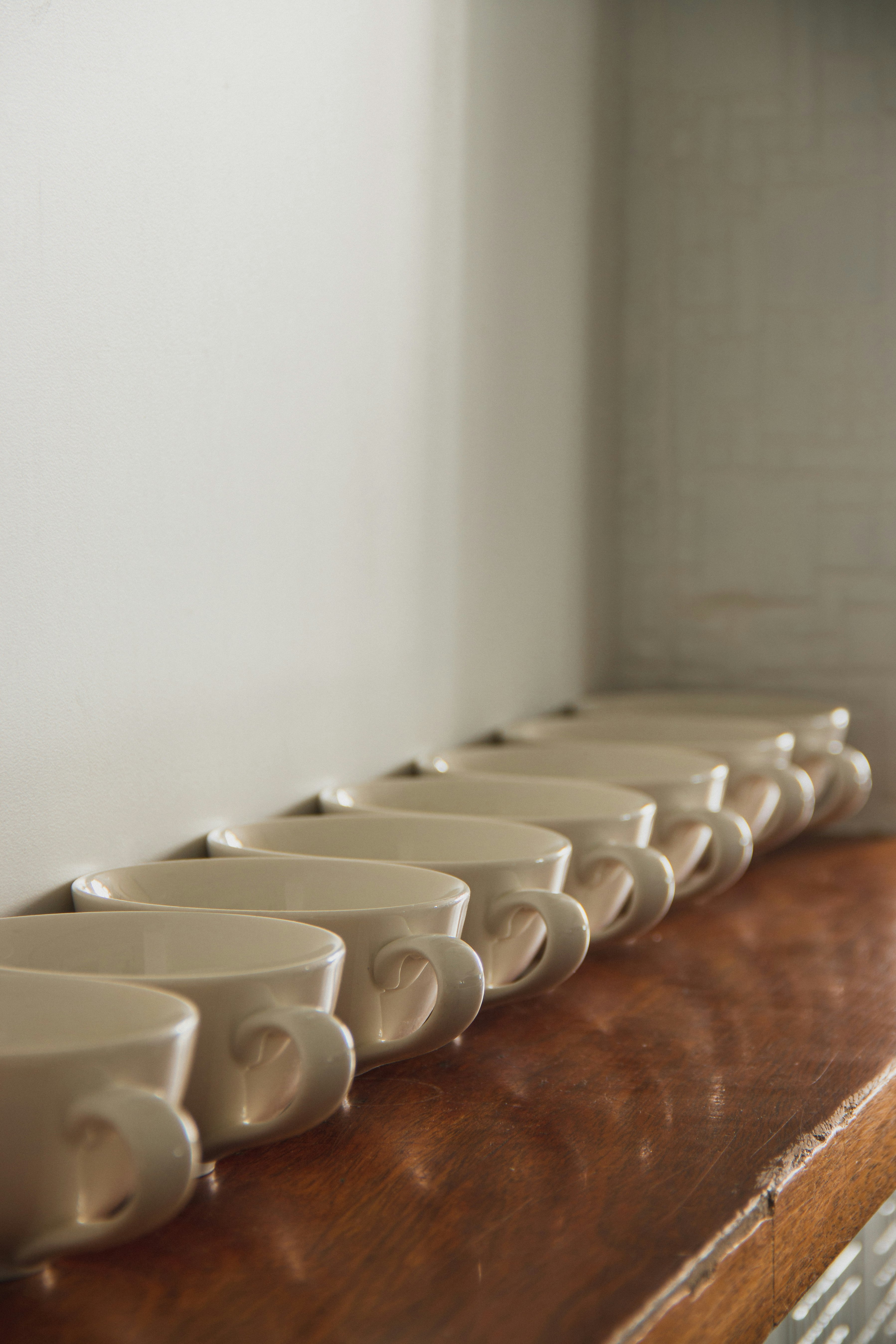 white ceramic mugs on brown wooden table